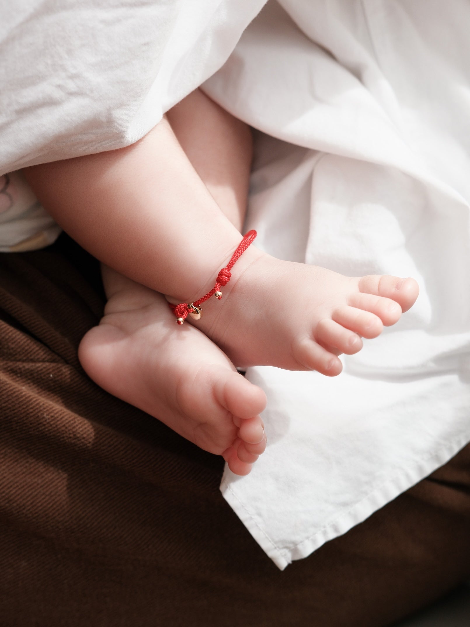 The Seed Adjustable Red Cord Baby Bracelet